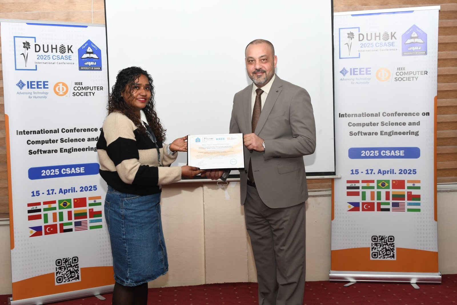 Certificate presentation in front of the CSASE 2025 / IEEE roll-up banners
